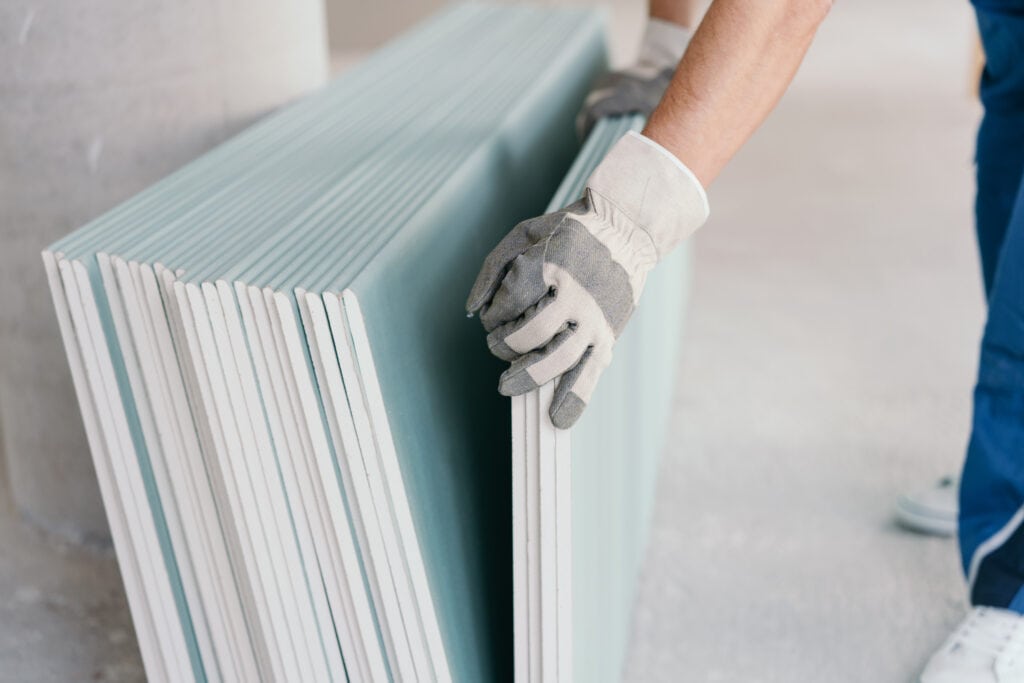 Builder,Taking,A,Sheet,Of,Chip,Board,Cladding,From,A