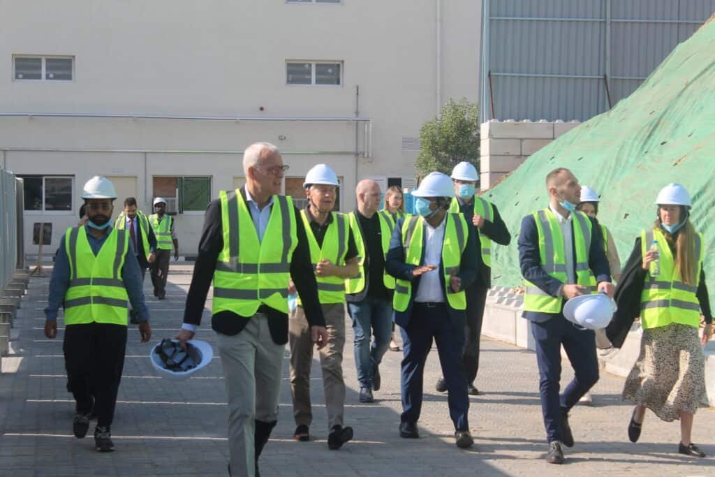 people in the vests walking in industrial environment
